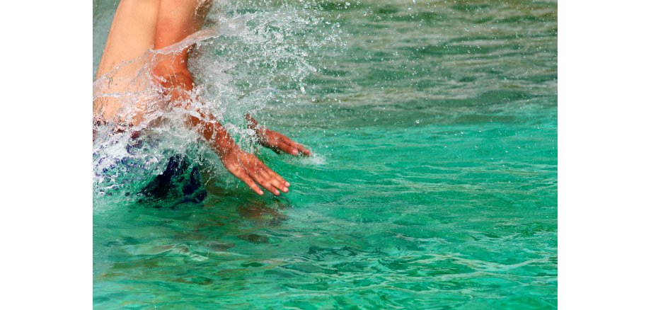 Foto einer Person, welche im Wasser planscht